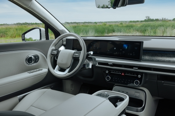 The IONIQ 9 driver's seat view, showing the steering wheel and the curved instrument and infotainment display
