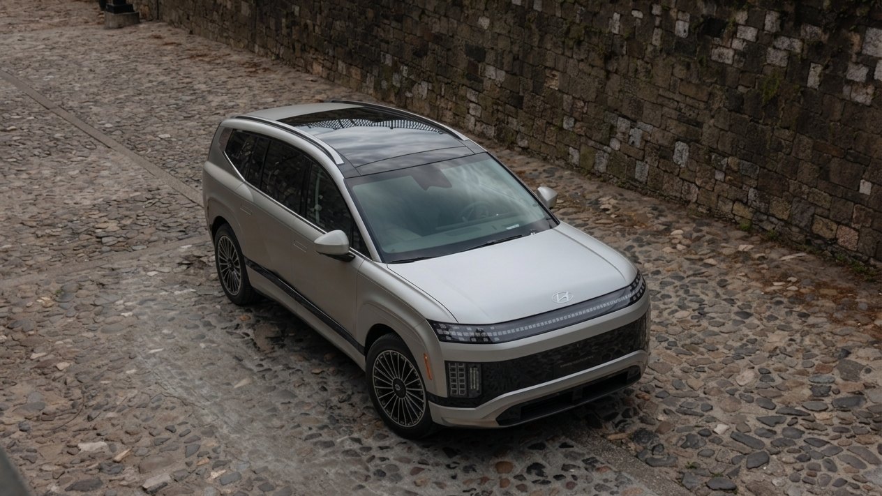 A Hyundai IONIQ 9 three-row electric SUV on a cobbled city street, seen from above